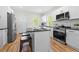 Modern kitchen with stainless steel appliances, white cabinets, black countertops, and a central island with bar seating at 2111 Holly Hill Dr, Decatur, GA 30032