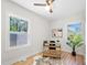 Home office with hardwood floors, two windows, a black desk and chair, a plant, and a hide rug at 2111 Holly Hill Dr, Decatur, GA 30032