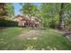 Expansive backyard with lush lawn, wooden deck, and mature trees at 5027 Castlewood Sw Dr, Lilburn, GA 30047