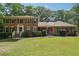 Charming two-story brick home with a well-manicured lawn, mature trees, and traditional design elements at 5027 Castlewood Sw Dr, Lilburn, GA 30047