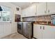 Modern laundry room with updated washer and dryer units and cabinetry at 5027 Castlewood Sw Dr, Lilburn, GA 30047