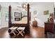 Cozy main bedroom featuring a four-poster bed, a fireplace, and natural light at 5027 Castlewood Sw Dr, Lilburn, GA 30047