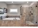 Luxurious bathroom with a soaking tub and frameless glass shower, with neutral stone tile and elegant fixtures at 10140 Grandview Sq, Duluth, GA 30097