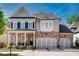 Charming two-story home features a stone facade, covered porch, and three-car garage at 10140 Grandview Sq, Duluth, GA 30097