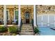 Charming stone home featuring a covered porch, a dark wood door, and a two-car garage at 10140 Grandview Sq, Duluth, GA 30097