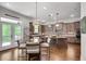 Kitchen featuring dark brown cabinetry, an island, a breakfast table, and a door to the backyard at 10140 Grandview Sq, Duluth, GA 30097