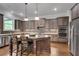 Well-lit kitchen boasts stainless steel appliances, center island, and beautiful backsplash at 10140 Grandview Sq, Duluth, GA 30097