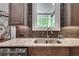 Close-up of a granite countertop, stainless steel sink, and designer backsplash in kitchen at 10140 Grandview Sq, Duluth, GA 30097