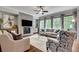 Living room features stone fireplace, large windows with backyard views, and comfortable seating arrangement at 10140 Grandview Sq, Duluth, GA 30097