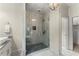 Modern bathroom features a glass enclosed shower with gray tile surround and a view to the closet at 727 Hammond Dr, Woodstock, GA 30188