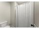 Simple bathroom featuring a white toilet and white shower curtain with a textured pattern at 727 Hammond Dr, Woodstock, GA 30188