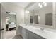 Bright bathroom with double sinks, large mirror, and view of a bedroom through the doorway at 727 Hammond Dr, Woodstock, GA 30188
