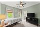Comfortable bedroom with natural light, view to the bathroom, ceiling fan and TV on a bureau at 727 Hammond Dr, Woodstock, GA 30188