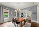 Bright dining area showcasing hardwood floors, stylish lighting and windows, leading to the living room at 727 Hammond Dr, Woodstock, GA 30188