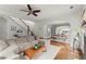Spacious living room features hardwood floors, ceiling fan, and seamlessly connects to the dining area at 727 Hammond Dr, Woodstock, GA 30188
