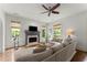Open concept living room with a fireplace, ceiling fan, and hardwood floors at 727 Hammond Dr, Woodstock, GA 30188