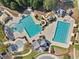 Aerial view featuring a community pool, winding waterslide, splashpad, and lush landscaping at 8640 Amsbury Way, Cumming, GA 30041