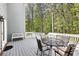 Open back deck with outdoor dining, white railings, and tranquil wooded views at 8640 Amsbury Way, Cumming, GA 30041