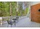 Back deck with outdoor seating, white railings, and a wooded view and brick exterior at 8640 Amsbury Way, Cumming, GA 30041