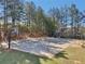 An outdoor basketball court surrounded by towering trees, perfect for neighborhood games and physical activity at 8640 Amsbury Way, Cumming, GA 30041
