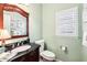 Stylish powder room with elegant mirror, vanity, and charming decor. Perfect for guests at 8640 Amsbury Way, Cumming, GA 30041