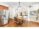 Open dining area with hardwood floors, modern chandelier, and stainless steel fridge at 8640 Amsbury Way, Cumming, GA 30041