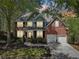 Beautiful two-story brick home exterior with well-maintained landscaping, an attached two-car garage, and a lovely front porch at 8640 Amsbury Way, Cumming, GA 30041