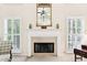 Elegant fireplace with white mantle and large windows, perfect for cozy evenings at 8640 Amsbury Way, Cumming, GA 30041