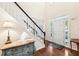 Bright foyer with hardwood floors, staircase with white risers, and a lamp table at 8640 Amsbury Way, Cumming, GA 30041