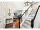 Welcoming foyer with hardwood floors, staircase with dark wood railing, and views into other rooms at 8640 Amsbury Way, Cumming, GA 30041
