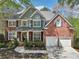 Inviting two-story brick home with a two-car garage and meticulously maintained landscaping at 8640 Amsbury Way, Cumming, GA 30041