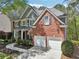 Classic brick and siding home with a two-car garage and well-kept front lawn at 8640 Amsbury Way, Cumming, GA 30041