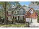 Charming two-story brick home with a well-manicured lawn, professional landscaping, and attached two car garage at 8640 Amsbury Way, Cumming, GA 30041