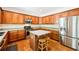 Well-equipped kitchen with stainless steel appliances, wooden cabinetry, and center island with stools at 8640 Amsbury Way, Cumming, GA 30041