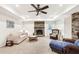 Cozy living room featuring a stone fireplace and ceiling fan at 8640 Amsbury Way, Cumming, GA 30041