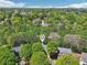 Aerial shot of a neighborhood showcasing homes surrounded by lush greenery and mature trees in a wooded area at 8640 Amsbury Way, Cumming, GA 30041