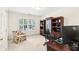 Well-lit home office with a large window, built-in bookshelves, and a functional workspace at 8640 Amsbury Way, Cumming, GA 30041