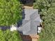 Overhead view of a well-maintained roof with mature trees surrounding the property and driveway at 8640 Amsbury Way, Cumming, GA 30041