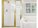 The bathroom features a shower with gold trim and a soaking tub with window view at 8640 Amsbury Way, Cumming, GA 30041