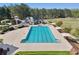 This aerial shot showcases a sparkling swimming pool and a thrilling water slide for endless summer fun at 8640 Amsbury Way, Cumming, GA 30041