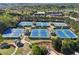 Aerial view showcasing multiple tennis courts surrounded by lush trees, offering a private and picturesque setting at 8640 Amsbury Way, Cumming, GA 30041