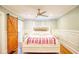 Main bedroom with decorative wainscoting, ceiling fan, and sliding barn door at 98 Chappell Nw Rd, Atlanta, GA 30314