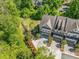 Aerial view of townhome with landscaped yard and two car garage in a green, wooded community at 2166 Sonoma Se Dr, Smyrna, GA 30080