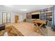 Open basement featuring hardwood floors, built-in shelving, a TV, plus seating and a wooden table with chairs at 2166 Sonoma Se Dr, Smyrna, GA 30080