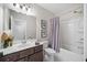 Bathroom featuring an expansive mirror, gray vanity, and shower-tub combination with a calming gray shower curtain at 2166 Sonoma Se Dr, Smyrna, GA 30080