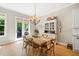 Charming dining area featuring a rustic wooden table, chandelier, and access to an outdoor patio, perfect for gatherings at 2166 Sonoma Se Dr, Smyrna, GA 30080