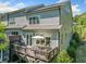 Rear exterior view of the home showcasing a wooden deck and patio areas surrounded by beautiful greenery at 2166 Sonoma Se Dr, Smyrna, GA 30080