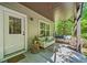 Outdoor patio featuring comfortable seating, a side table, and views of the wooded backyard beyond at 2166 Sonoma Se Dr, Smyrna, GA 30080