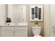 Modern bathroom featuring a white vanity, neutral walls, and a framed art print above the toilet at 2429 Livi Ln, Buford, GA 30519