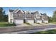 Stylish townhome exteriors with brick and siding, attached garages, and manicured lawns at 2429 Livi Ln, Buford, GA 30519